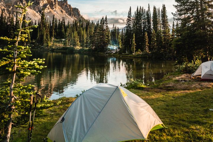 Scenic camping spot beside a reflective mountain lake in British Columbia, Canada.